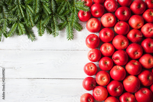 Christmas background with red apples, fir branches