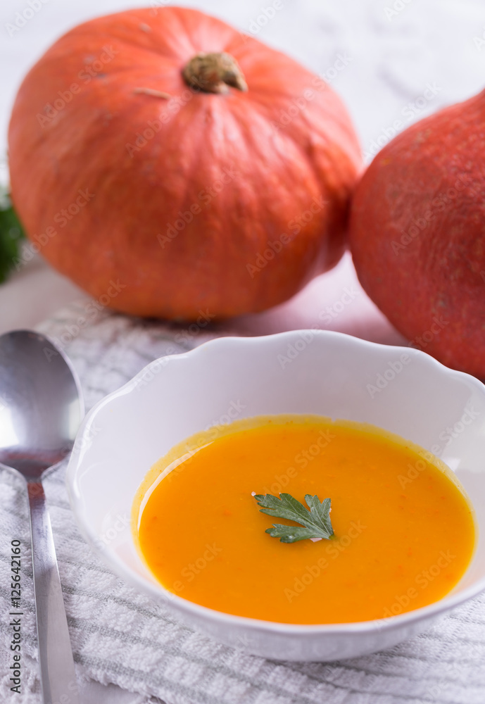 Autumn pumpkin soup on white tablecloth. Autumn pumpkin soup on white tablecloth.