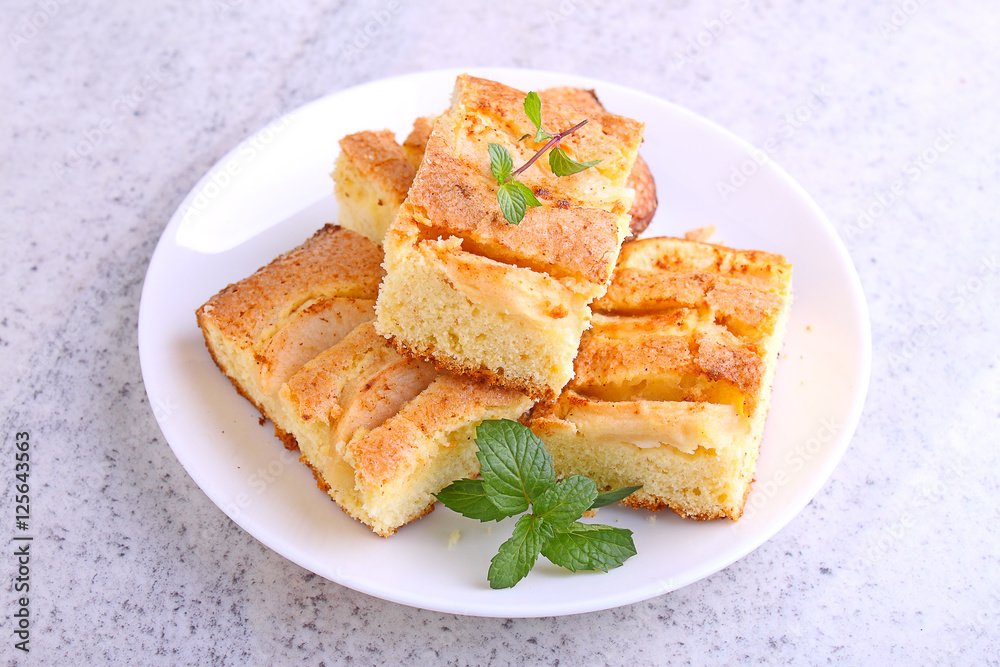 homemade pie with apples and cinnamon is cut slices on a plate, wooden background homemade pie with apples and cinnamon is cut slices on a plate, wooden background