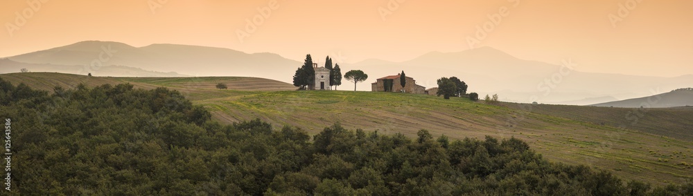 panorama of orange morning in Tuscany with old church