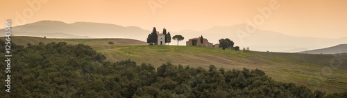 panorama of orange morning in Tuscany with old church