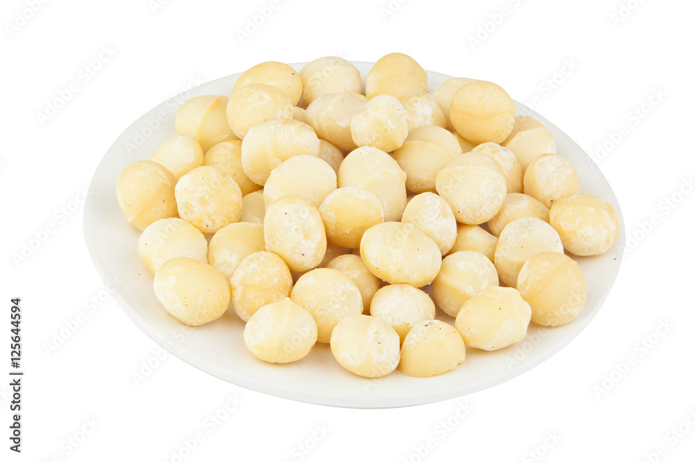 delicious macadamia nuts on plate on wooden background delicious macadamia nuts on plate on wooden background
