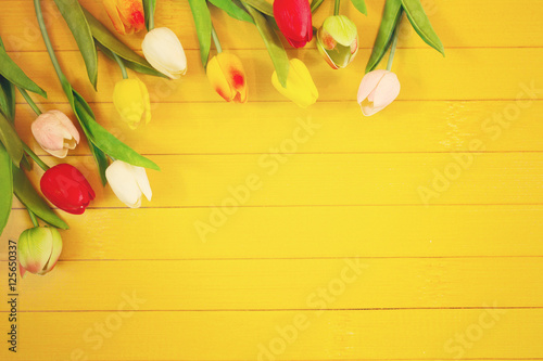Tulips flowers on light wooden background.