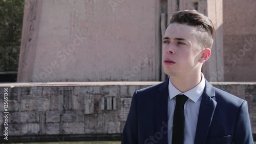 Young business man smoking cigarette in the street