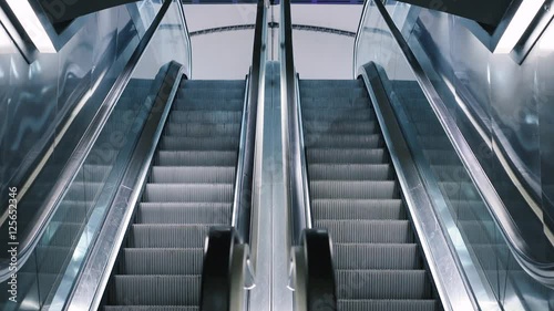 Close-up shot of empty moving staircase running up and down. Modern escalator stairs, which moves indoor.