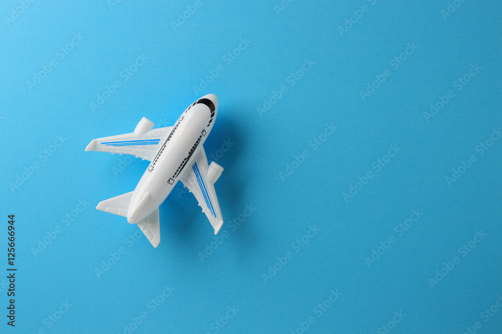 Obraz premium samolot zabawka na niebieskim tle papieru