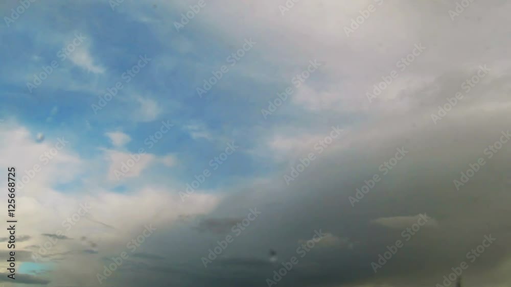 Looking at moving clouds through window glass with rain drops. Looking at moving clouds through window glass with rain drops.