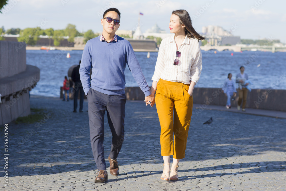 Fototapeta premium A loving couple walk on embankment of a river