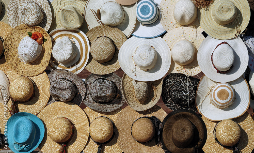 hats from the sun on a shop window. Photo partially tinted.