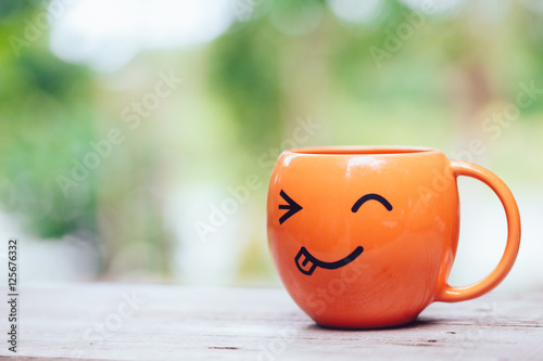 smile happy mug on wood table, funny happy drinking coffee concept.