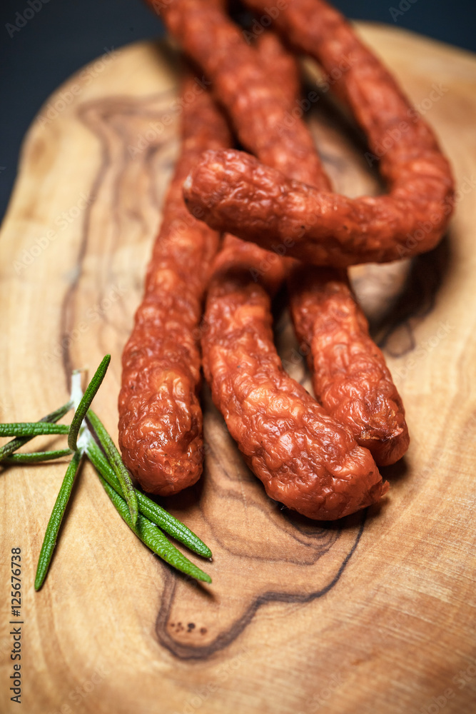 Closeup of fresh thin sausages on wooden background Closeup of fresh thin sausages on wooden background