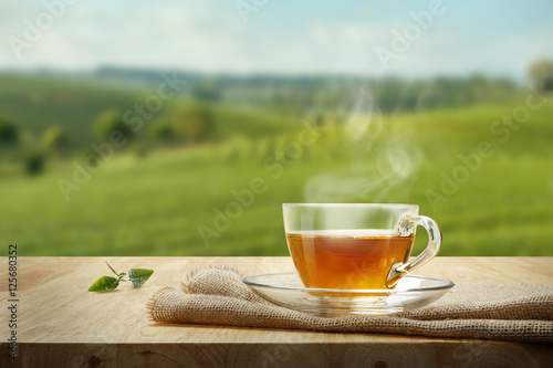 Warm cup of tea and tea leaf and sack on the wooden table and th