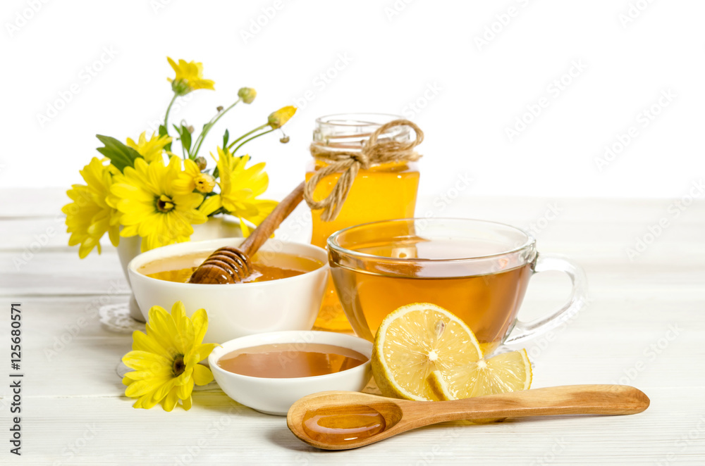 Yellow flowers, tea , lemon and honey on wooden table