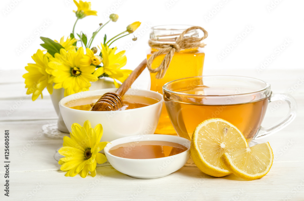 Yellow flowers, tea , lemon and honey on wooden table Yellow flowers, tea , lemon and honey on wooden table