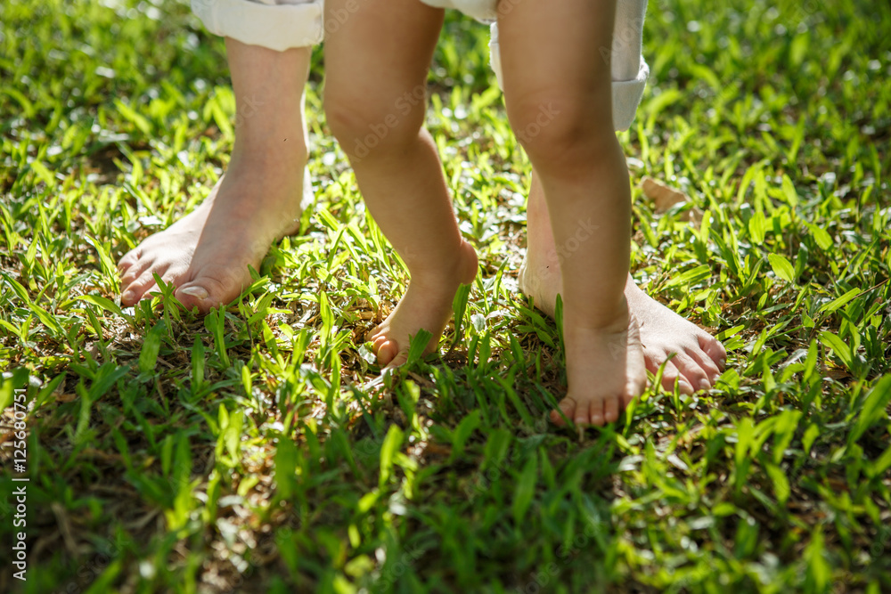 Portrait of mother and baby legs. First steps.