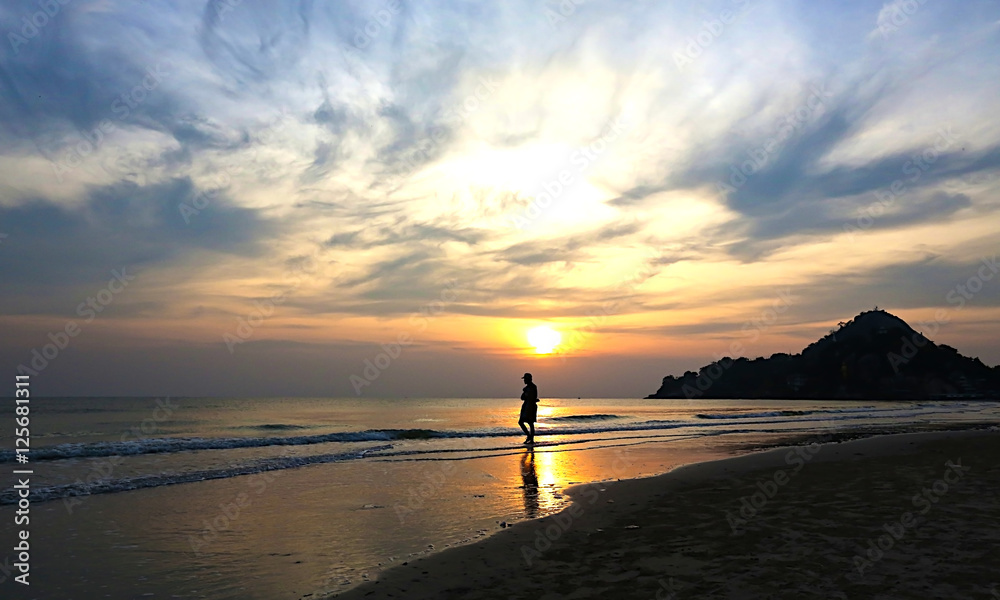 Fototapeta premium Silhouette of maื walking on the beach