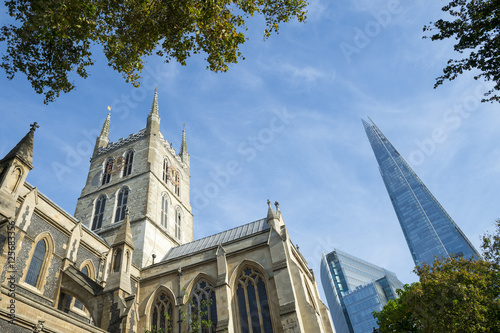 London skyline featuring the old architecture of the Southwark Cathedral with the modern Shard skyscraper beyond photo