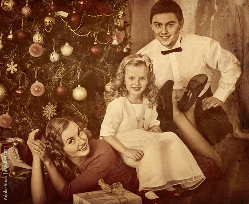 Family with children pose under Christmas tree. Black and white retro family portrait. photo