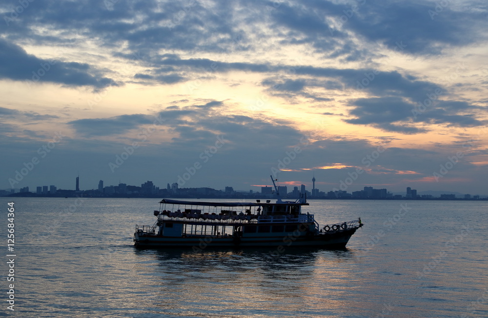 Silhouette of a passenger ferry boat during sunrise
