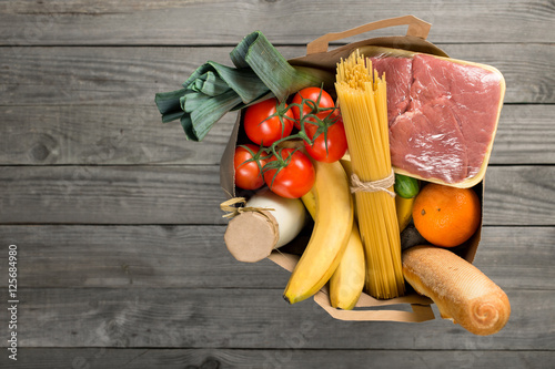 фотографія Paper bag of groceries on wooden background