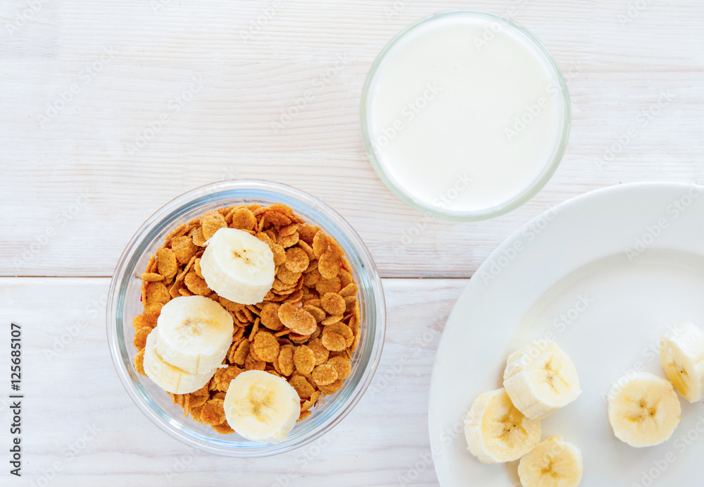 flakes in bowl with banana on wooden background top view flakes in bowl with banana on wooden background top view
