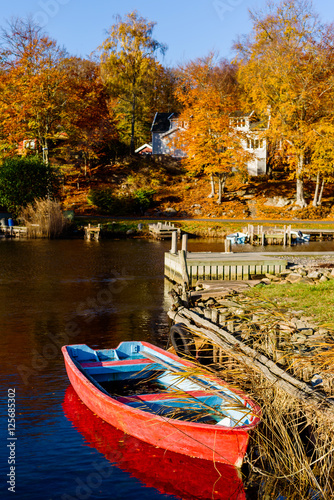 Small red rowboat in coastal landscape in fall. Bokevik outside Ronneby in Sweden.