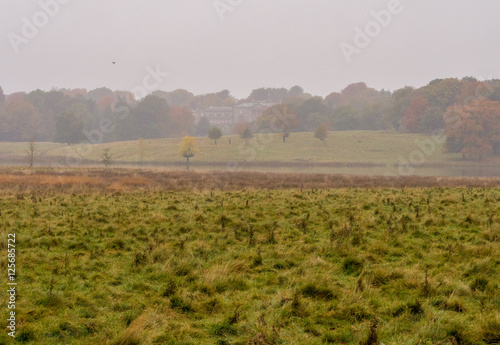 Early morning Autumn mist over lake at Tatton Park, Knutsford, Cheshire, UK