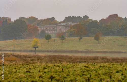 Early morning Autumn mist over lake at Tatton Park, Knutsford, Cheshire, UK