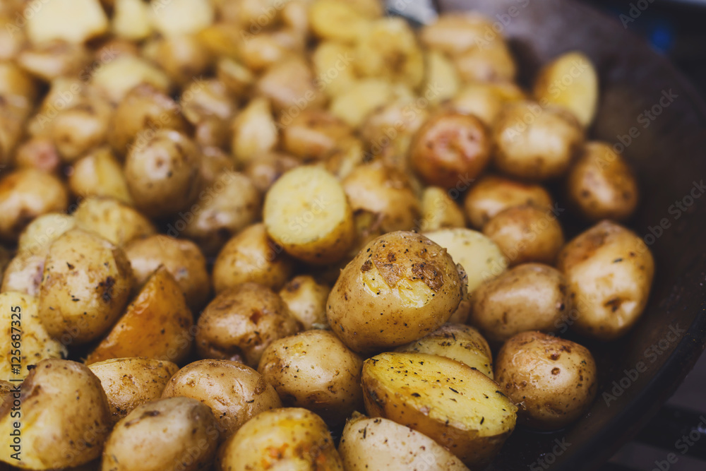 Roasted potatoes cooked in metal cauldron pot Roasted potatoes cooked in metal cauldron pot