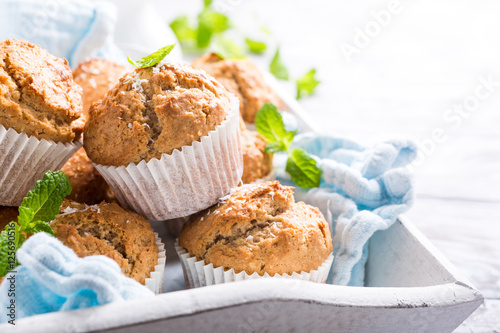 Fotografia Delicious homemade coconut cinnamon muffins and mint leafs on old white tray