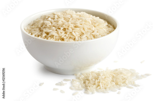 Bowl of long grain white rice isolated on white. Spilled rice.