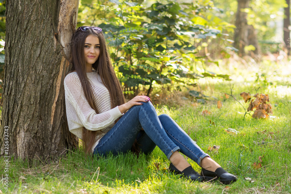 Portrait of young romantic brunette woman seating at the tree dr Portrait of young romantic brunette woman seating at the tree dr