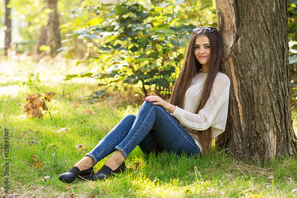 Portrait of attractive brunette girl at the tree in park in autu Portrait of attractive brunette girl at the tree in park in autu