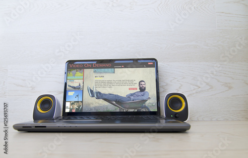Fényképezés Pay per view concept: video on demand website on the screen of laptop and external speakers to the sides