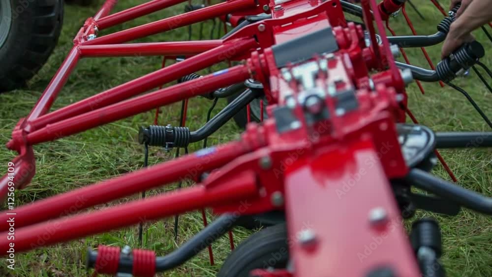 We can see a machine for turning around grass. A man is about to start working on the field with grass. Close-up shot.
We can see a machine for turning around grass. A man is about to start working on the field with grass. Close-up shot.