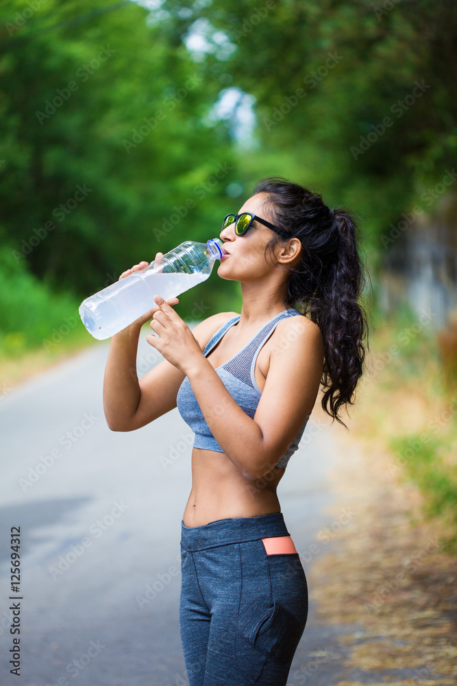 young woman holding a bottle in the forest young woman holding a bottle in the forest