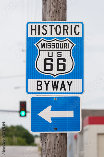 Historic route 66 sign with blur traffic lights background in Mi