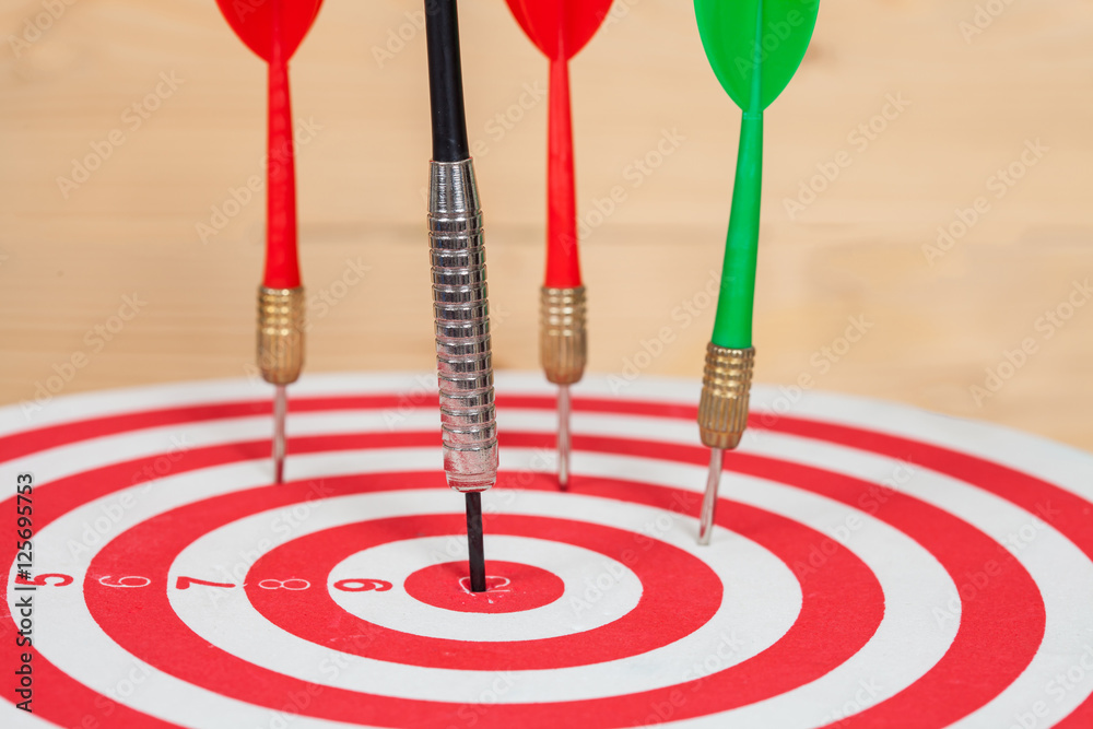dart arrow and dartboard on wood background dart arrow and dartboard on wood background