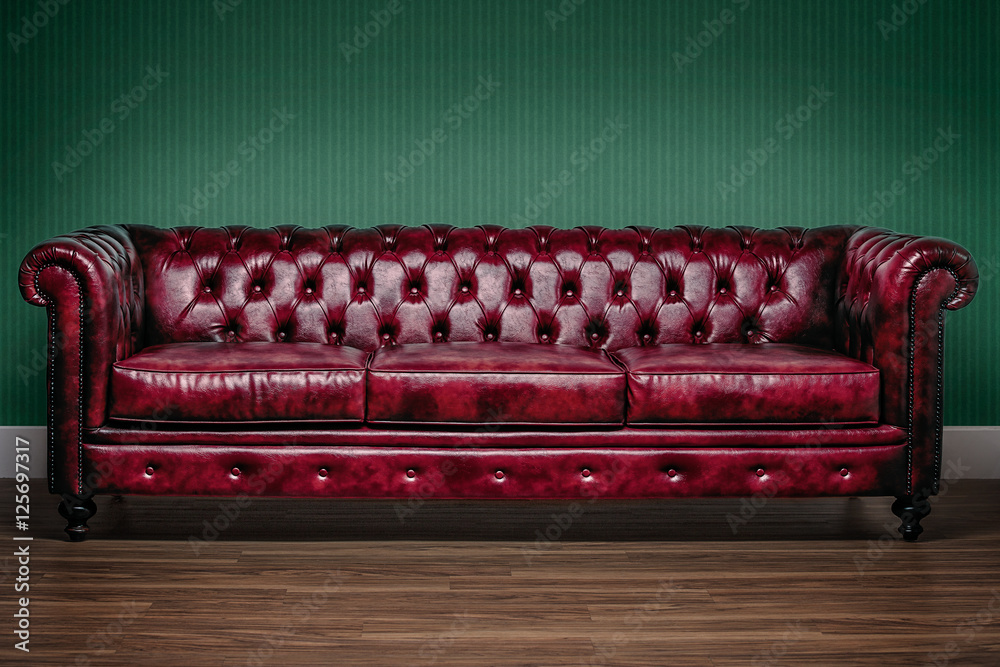 Red chesterfield sofa with green wallpaper background foto de Stock | Adobe  Stock