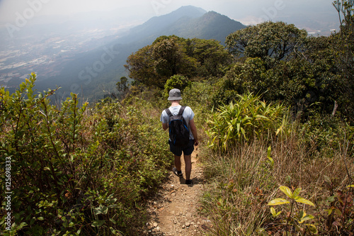 Hiker with backpack standing on top of a mountain. Vietnam, Dalat. travel concept