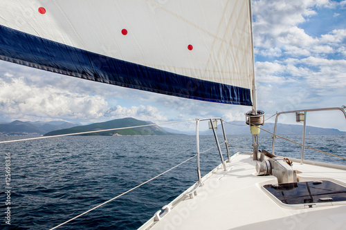 Front part of a sailboat, full sails in Ionian sea