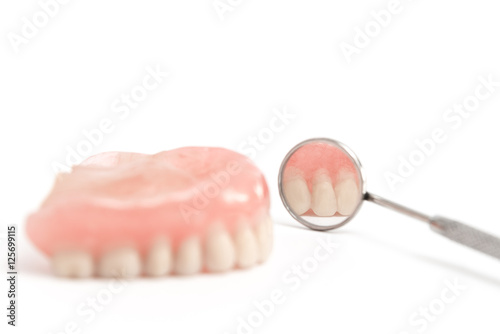 upper dentures and dental mirror on white background,Selective f