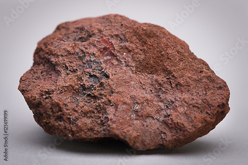 Natural sample of iron ore over gray background.