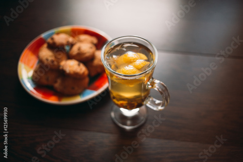 Autumn Still Life: Herbal tea on a wooden table near the window. The sun's rays on a cup of brewed tea. A cup of hot chayas pichenem on a sunny day on the background of the window. Autumn tea