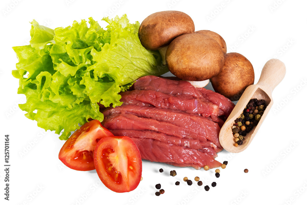 Pieces of raw beef, mushrooms, tomato, lettuce and spices isolated.