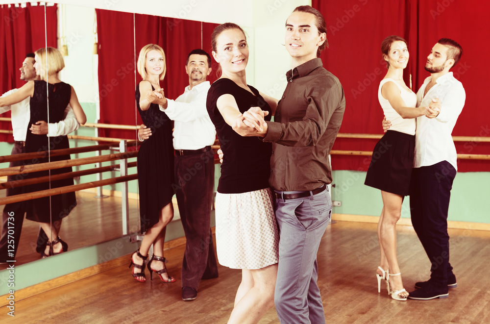 men and women having dancing class in studio
