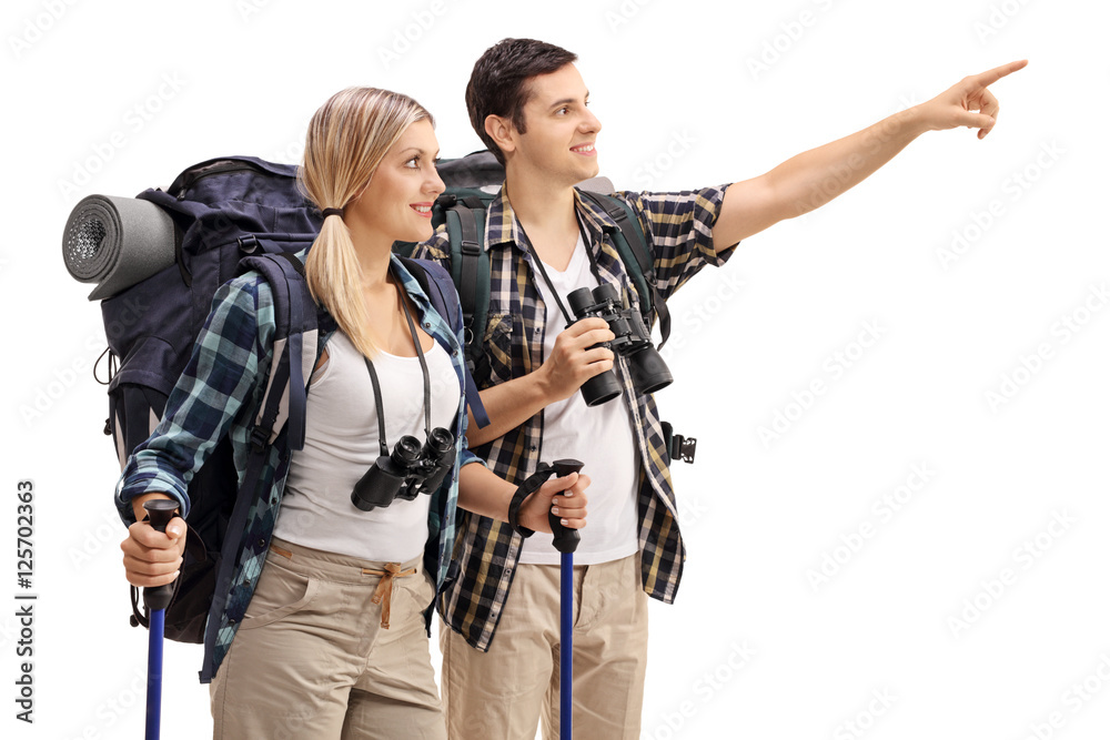 Male hiker showing something in the distance to female hiker Male hiker showing something in the distance to female hiker