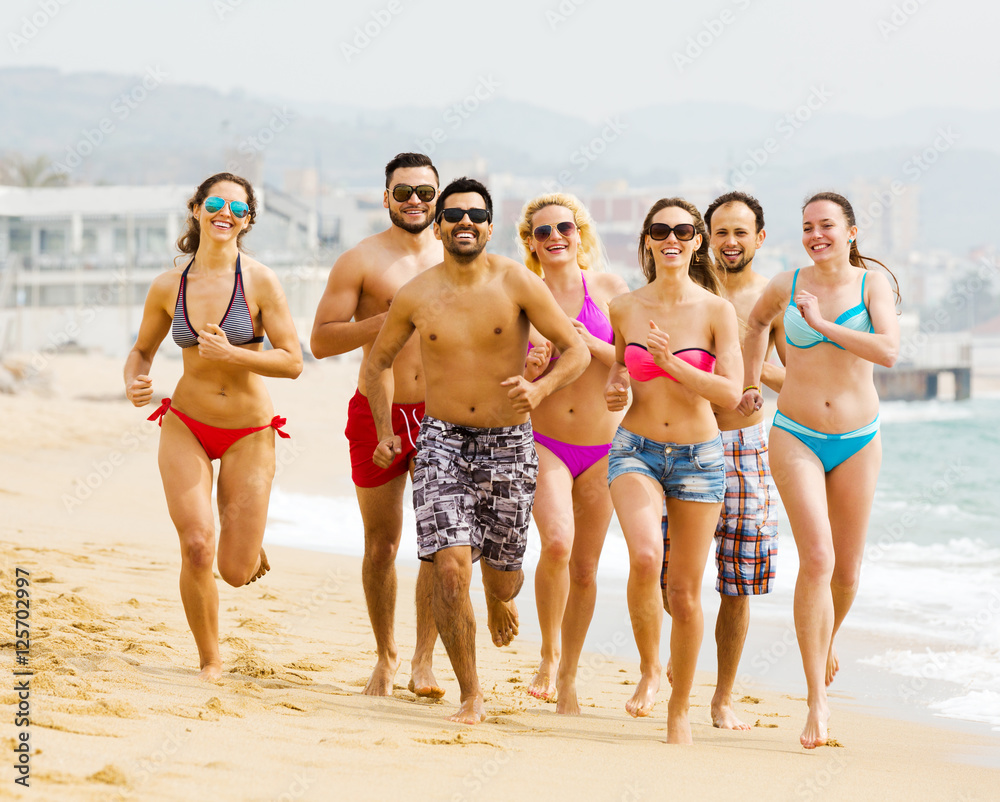 Happy people running at beach
