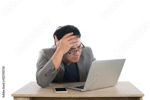 Stressed businessman work  with laptop sitting at table isolated