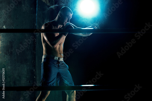 Male boxer boxing in a dark studio © master1305